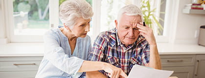 Worried senior couple checking their bills.