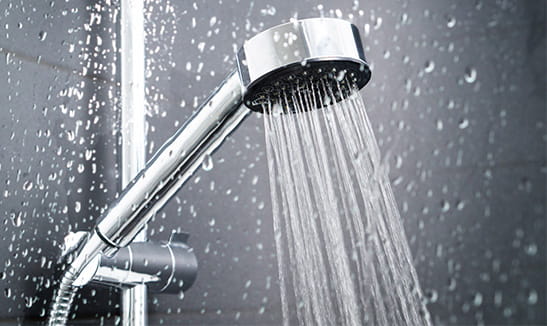 Water running from shower head and faucet in modern bathroom. 