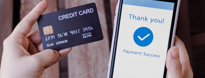 Woman hands holding credit card and using smart phone for online payment