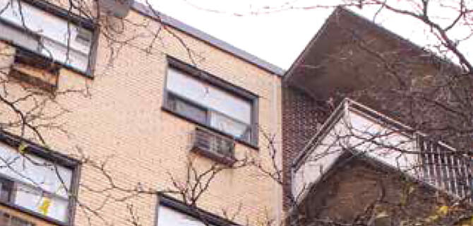 The exterior of a small brown multi-unit building