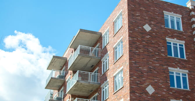 a multi residential building with blue sky in the background