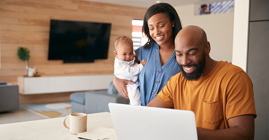 African American family with baby daughter using laptop to check information.