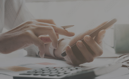 A person using a phone and a calculator.