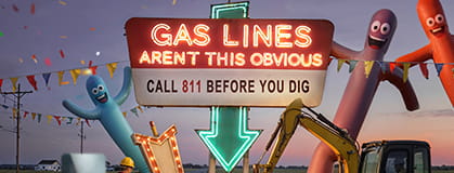 Light sign board saying "Gas lines aren't this obvious" with arm inflatables in the backgroud
