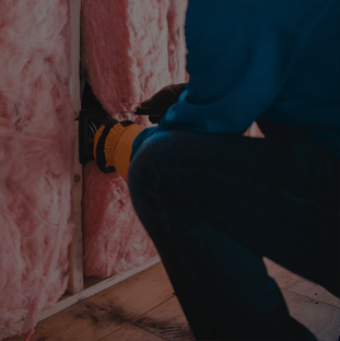 Person installing insulation in a house